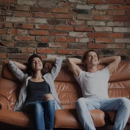 A couple relaxing on a leather sofa